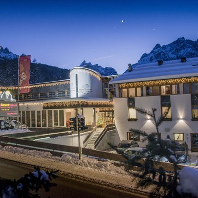 Alpine Stays for all Generations by Family Rainer Hotel Family Resort Rainer im Schnee bei Nacht vor Bergkulisse mit Lichterketten