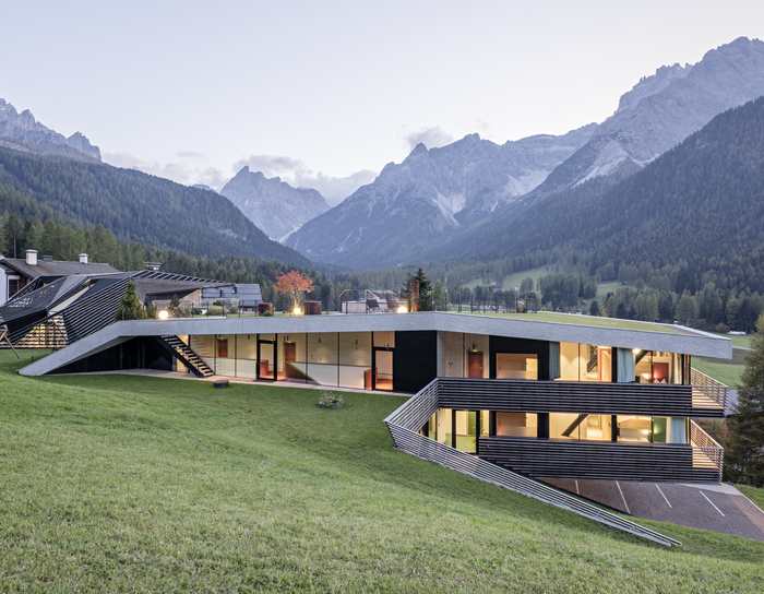 1 Familienhotel in Südtirol und 3 Residences: Family Resort Rainer Modernes Haus mit großen Fenstern auf einem Hang mit Bergblick