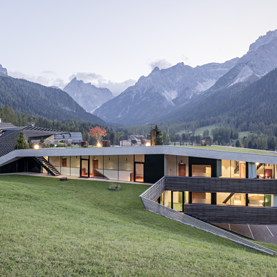 1 Familienhotel in Südtirol und 3 Residences: Family Resort Rainer Modernes Haus mit großen Fenstern auf einem Hang mit Bergblick