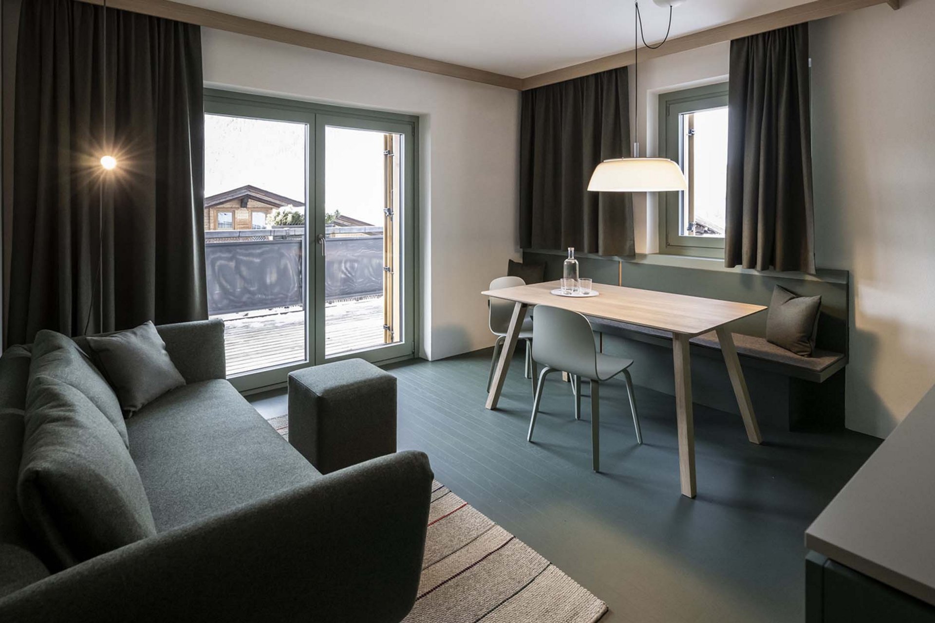 Stylish holidays at the Residence Paramount Alma Modern living room with sofa, dining table, and balcony with mountain view