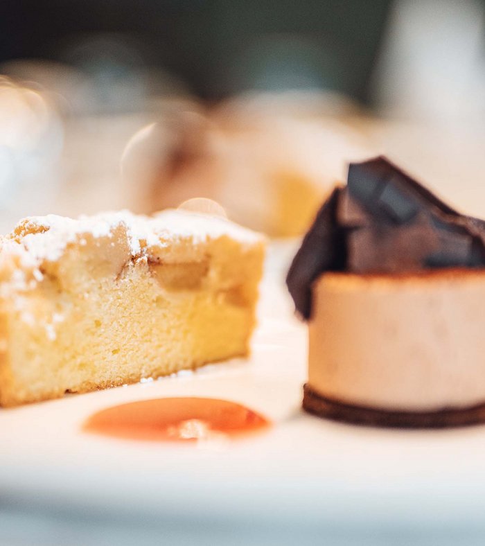 Family holidays at a gluten-free hotel A slice of cake and a small chocolate dessert on a white plate