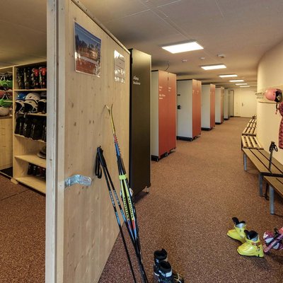 Alpine Stays for all Generations by Family Rainer Skiaufbewahrung mit Helmen, Skischuhen und Skistöcken in einem Raum mit Schränken