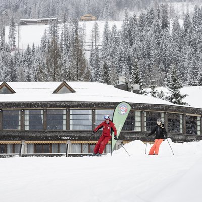 1 Familienhotel in Südtirol und 3 Residences: Family Resort Rainer Schnee bedecktes Hotel in verschneitem Bergdorf mit Menschen im Freien