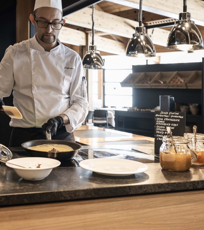 Family holidays at a gluten-free hotel Chef preparing an omelette in a modern kitchen