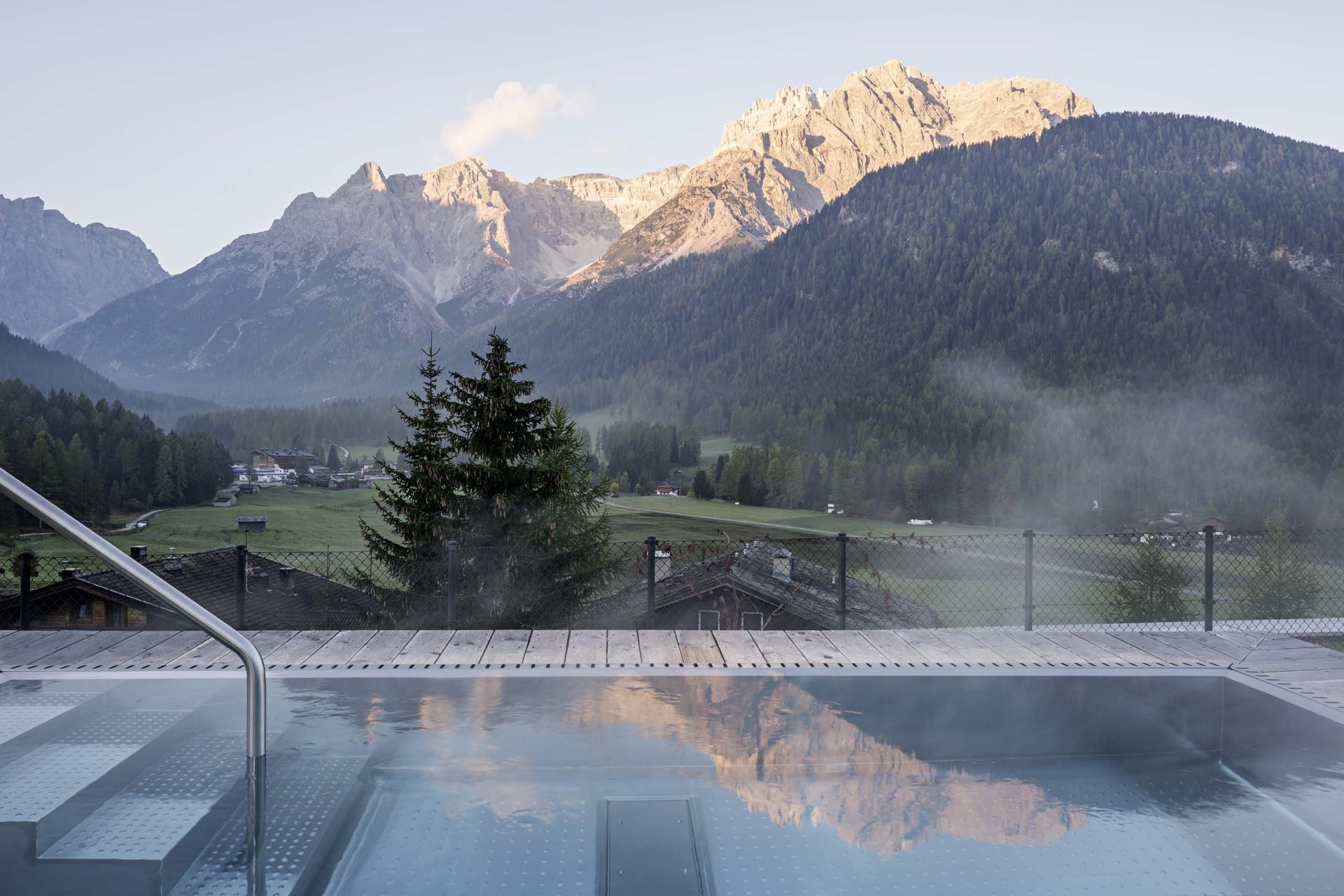 Stylish holidays at the Residence Paramount Alma Steaming pool with Dolomites mountain view at sunrise