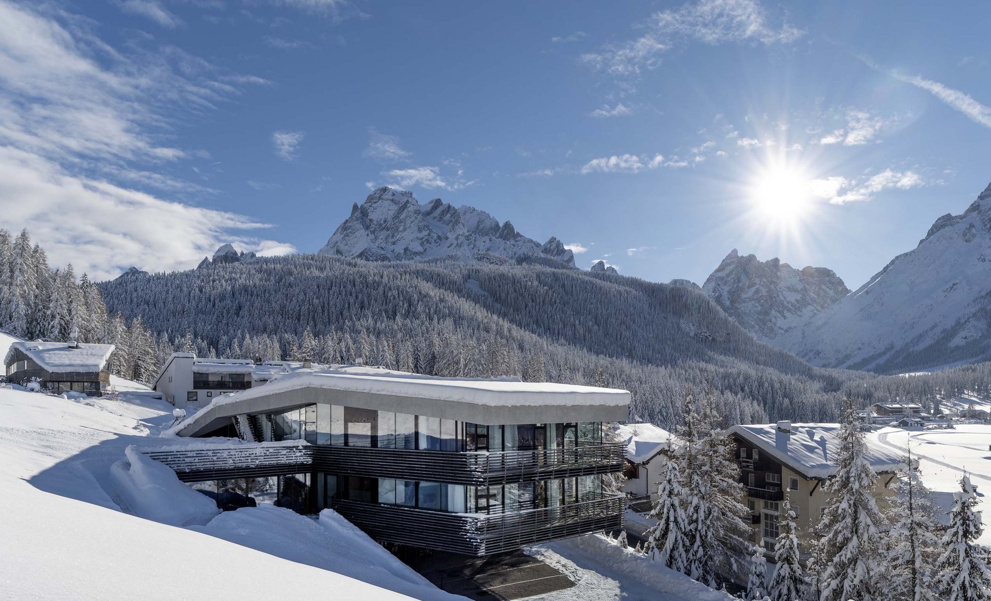 Stylish holidays at the Residence Paramount Alma Modern hotel in snow with snowy mountains and clear blue sky