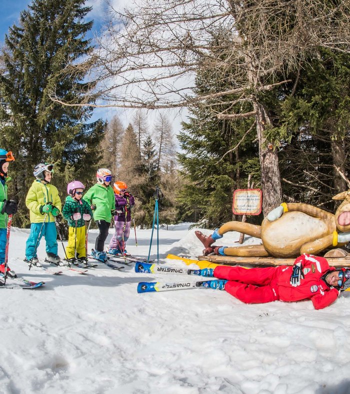 True adventure at our family hotel in the Dolomites! Children skiing with instructor next to a funny reindeer figure in the snow